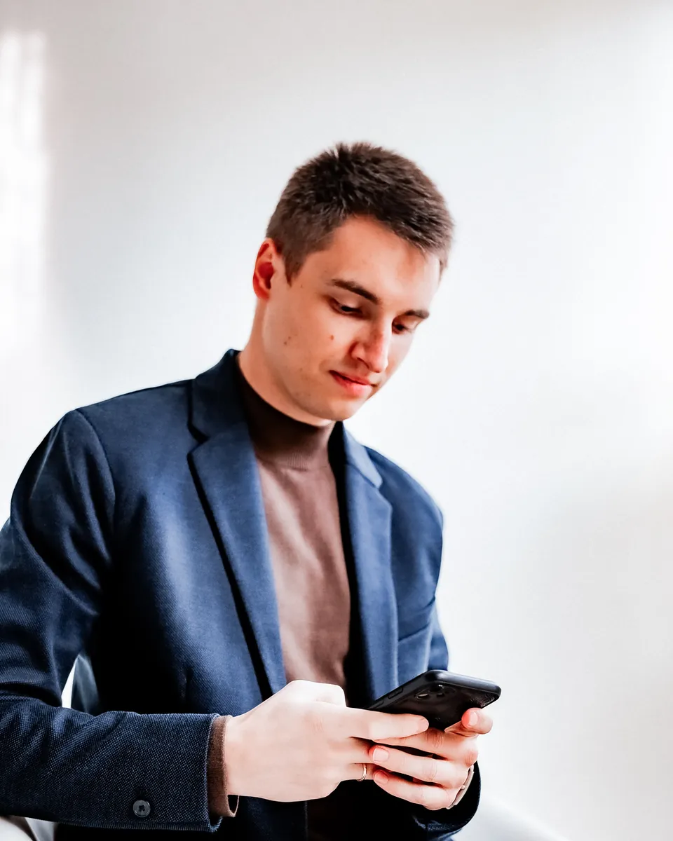 Artem si v štúdiu prezerá Instagram klienta na telefóne